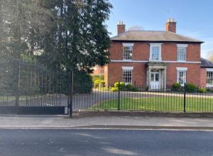 a fence in front of a brick house at Creamore Grove Wem Shrewsbury in Wem