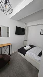 a bedroom with a bed and a tv on the wall at Apartament Sun Hill in Wisła