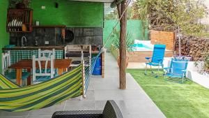 a hammock in a patio with a table and chairs at GuestReady - El Pinar isla del Hierro in El Pinar del Hierro