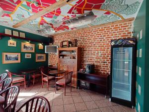 a restaurant with tables and chairs and a brick wall at Otrā Elpa in Valka