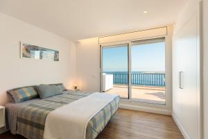 a bedroom with a bed and a view of the ocean at La Escala- Costa Brava pool duplex apartment in L'Escala +15 photos