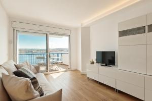 a living room with a couch and a television at La Escala- Costa Brava pool duplex apartment in L'Escala