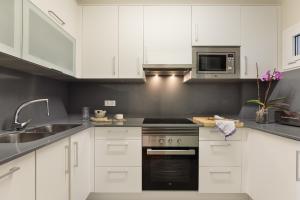 a kitchen with white cabinets and a stove top oven at La Escala- Costa Brava pool duplex apartment in L'Escala