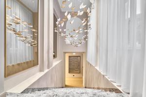 a hallway with a chandelier in a building at Villa Patriot Boutique Hotel in Mariánské Lázně