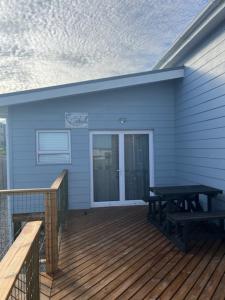 a porch with a picnic table on a deck at Net Genoeg in De Kelders +2 photos