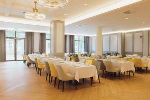 a dining room with white tables and yellow chairs at Primorski Hotel in Saints Constantine and Helena