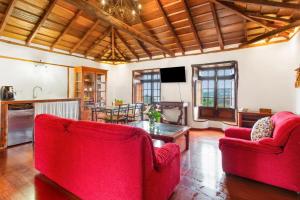 a living room with two red chairs and a table at La Paredita Casa Taoro in Tanque
