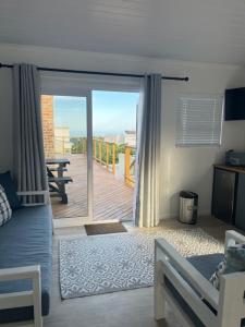 a bedroom with a bed and a sliding glass door at Net Genoeg in De Kelders