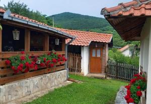 a house with red flowers on a fence at Ramaća House in Ramaća