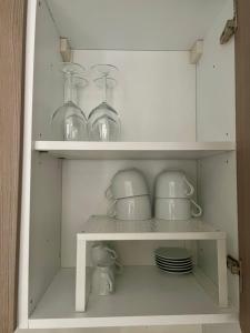 a white cabinet with dishes and glasses on it at TedHouse in Praia a Mare