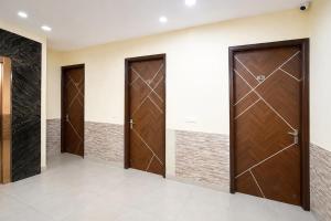 a row of wooden doors in a hallway at FabHotel Sager Inn in Gurgaon