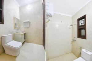 a white bathroom with a toilet and a shower at FabHotel Sager Inn in Gurgaon +28 photos