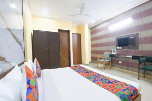 a bedroom with a bed and a desk and a tv at FabHotel Sager Inn in Gurgaon