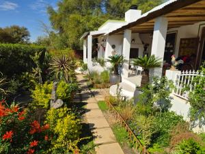 a garden in front of a house with flowers at Django's in Riebeek-Kasteel