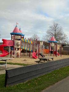 a playground in a park with tables and slides at Finca Leberto in Renesse