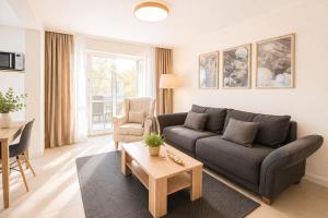 a living room with a couch and a table at Villa Manatee mit Sauna & Fitness in Ostseebad Sellin
