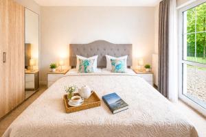 a bedroom with a bed with a book on a tray at Villa Manatee mit Sauna & Fitness in Ostseebad Sellin