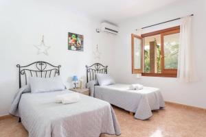 a bedroom with two beds and a window at Villa Son Tretze by Villa Plus in Biniparrell