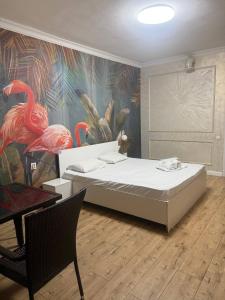 a bedroom with a bed and a wall with flamingos at INFINITY Hotel&Spa in Almaty