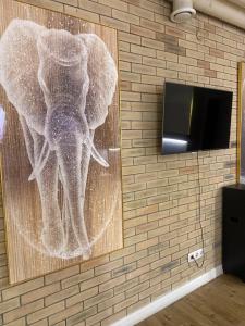 a picture of an elephant on a wall with a tv at INFINITY Hotel&Spa in Almaty