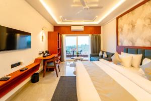 a hotel room with a large bed and a desk at Ritz Valley Resort in Mahabaleshwar