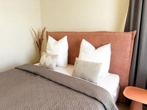 a bedroom with a bed with white pillows at ME LIVING Villa am Kurpark - Design Apartments in Bad Salzuflen