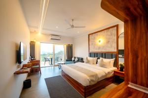 a bedroom with a large bed and a living room at Ritz Valley Resort in Mahabaleshwar +66 photos