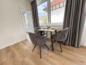 a dining room with a table and chairs and a window at ME LIVING Villa am Kurpark - Design Apartments in Bad Salzuflen
