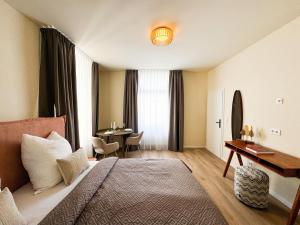 a hotel room with a bed and a desk at ME LIVING Villa am Kurpark - Design Apartments in Bad Salzuflen