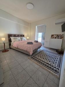 ein Schlafzimmer mit einem Bett und einem Teppich auf dem Boden in der Unterkunft NeliFlat in Lefkandi Chalkida