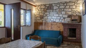 a living room with a blue couch and a stone fireplace at House Katarina by Villas Guide in Blato