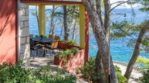 a house with a table and chairs on a porch overlooking the water at House Katarina by Villas Guide in Blato