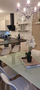 a glass table with white chairs and a dining room at Mutti 's Haus -Zur Südheide in Wahrenholz