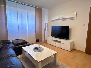 a living room with a couch and a tv and a table at Wasserburg 1 I Familienfreundlich - Ruhig & Erdgeschoss I Parkplatz inkl in Paderborn
