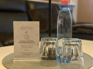 a bottle of water and two glasses on a table at Wasserburg 1 I Familienfreundlich - Ruhig & Erdgeschoss I Parkplatz inkl in Paderborn