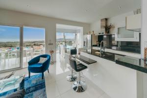 a kitchen with a counter and blue chairs in it at WELCS CASA 335 EMP con jacuzzi y terraza in Selva de Mar