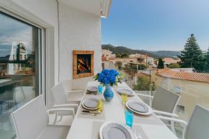 a white dining table with white chairs and a fireplace at WELCS CASA 335 EMP con jacuzzi y terraza in Selva de Mar