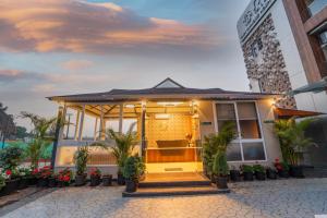 a building with a gazebo with plants on it at Ritz Valley Resort in Mahabaleshwar