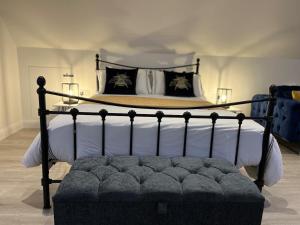 a bedroom with a large bed with a black frame at Loft apartment in Herstmonceux
