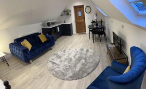 a living room with two blue couches and a table at Loft apartment in Herstmonceux