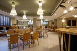 a restaurant with wooden tables and chairs and lights at Best Western Plus Hotel Globus in Rome