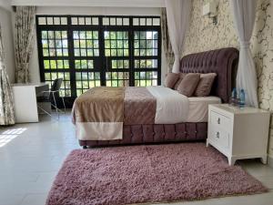 a bedroom with a large bed with a pink rug at Silva Montana in Mount Kenya +66 photos