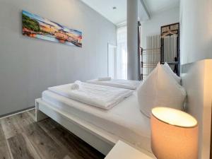 a white bed in a room with a picture on the wall at City-Apartment Timeless in Berlin