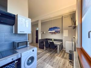 a kitchen and dining room with a washing machine and a table at City-Apartment Timeless in Berlin