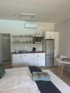 a kitchen with a large white bed in a room at The Dunes #10 Keurboomstrand in Plettenberg Bay
