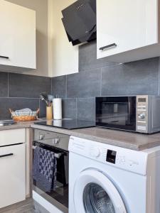 a kitchen with a washer and a microwave at City-Apartment Timeless in Berlin +4 photos