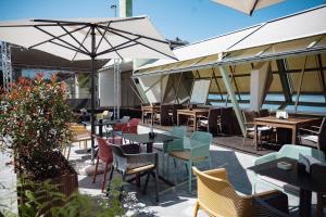 ein Restaurant mit Tischen, Stühlen und Sonnenschirmen in der Unterkunft MC Hotel in Žalec