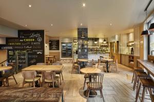 a restaurant with wooden tables and chairs and a bar at hub London - Tower Bridge in London