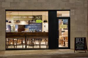 a store window with tables and chairs in it at hub London - Tower Bridge in London