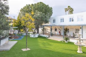 an open courtyard with a tree and grass at Cielito Lindo Tu hogar temporal con encanto in Torrent